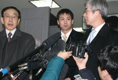 ２日、韓国・仁川地裁での公判後、記者団の質問に答える冨田尚弥選手（中央）